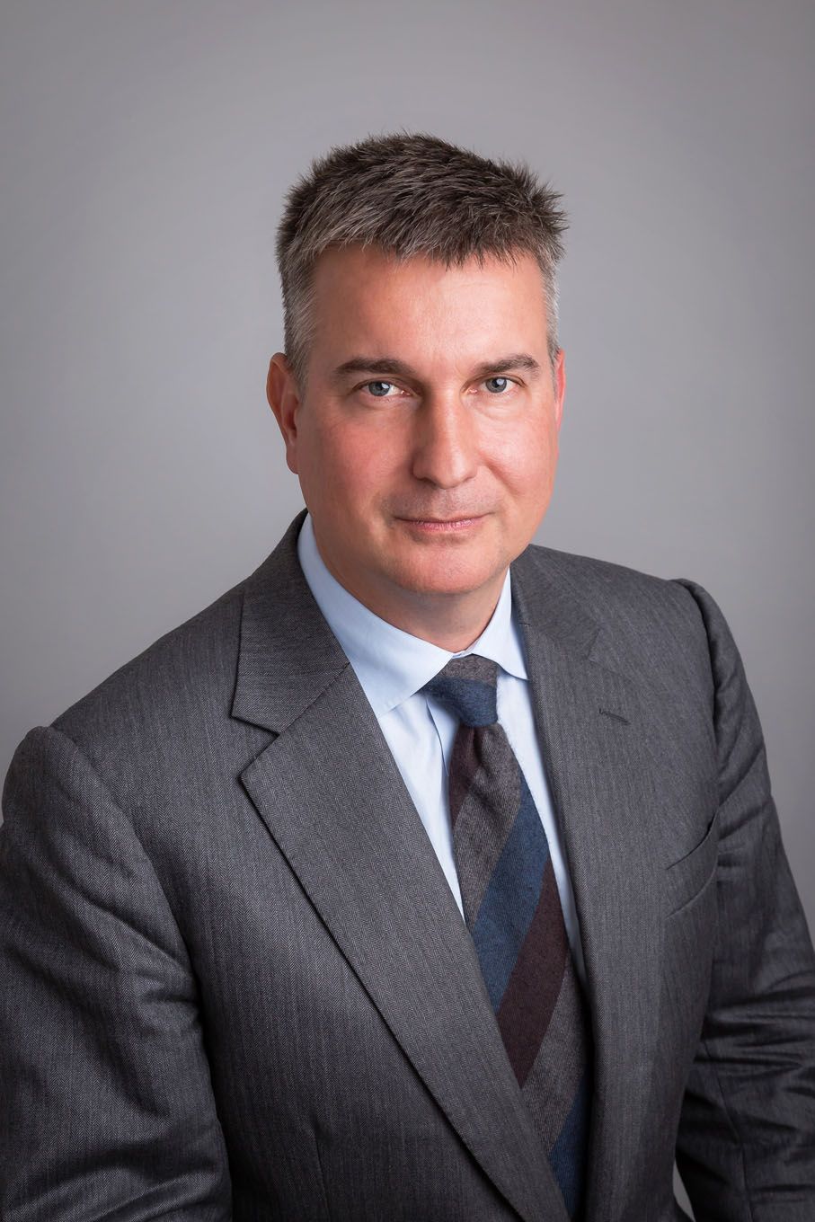 A portrait of a man taken in a studio set up with backdrop and lighting equipment